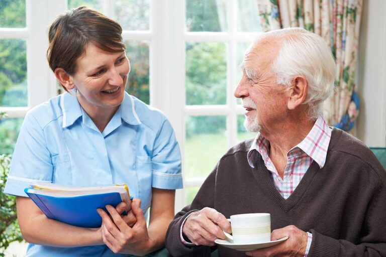 Older adult and family caregiver reviewing belongings in a welcoming assisted living room.